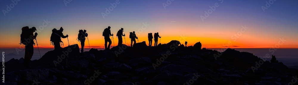 Hikers at sunrise the horizon ablaze with color