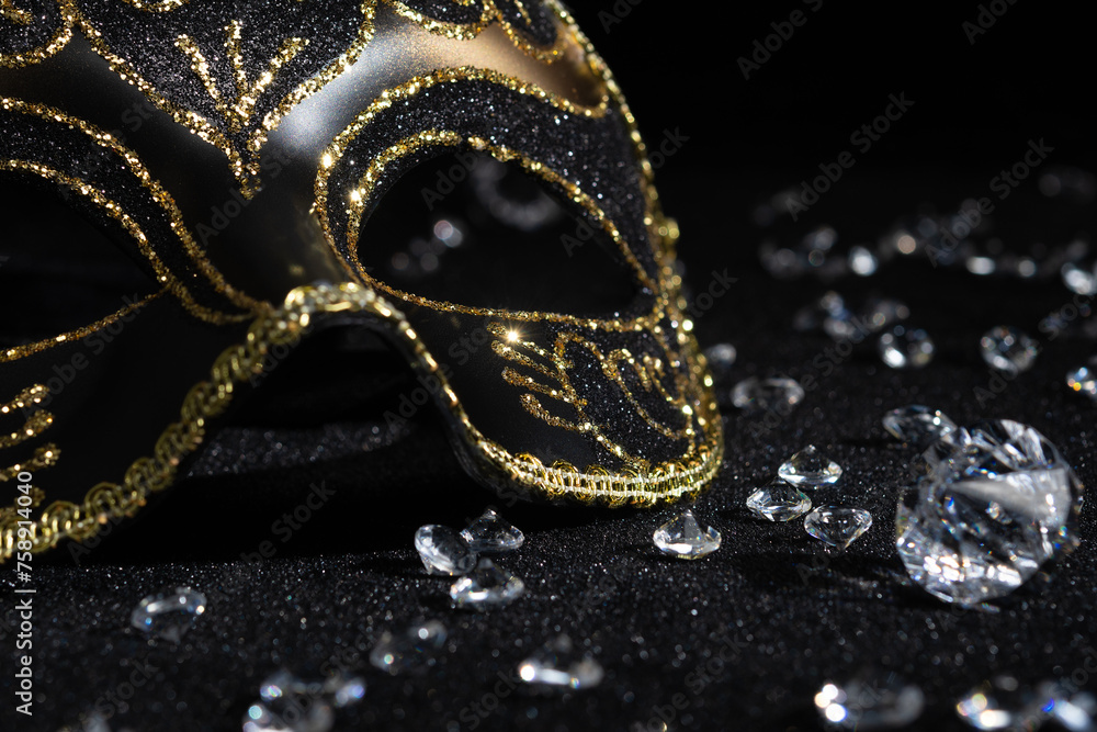 Close-up view of Carnival gold mask with diamonds on black background.