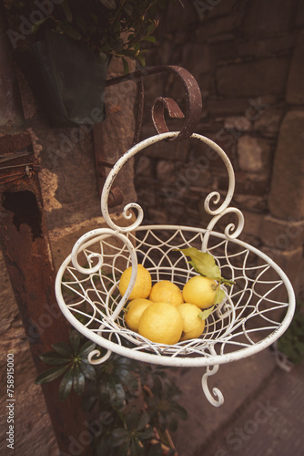 Yellow lemons in an iron basket in the street of Italy. Fresh lemons in supermarket. Concept of selling organic fruit.