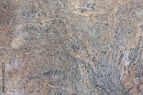 Detailed close up view of a textured granite surface, showcasing the intricate patterns and colors found in the natural stone.