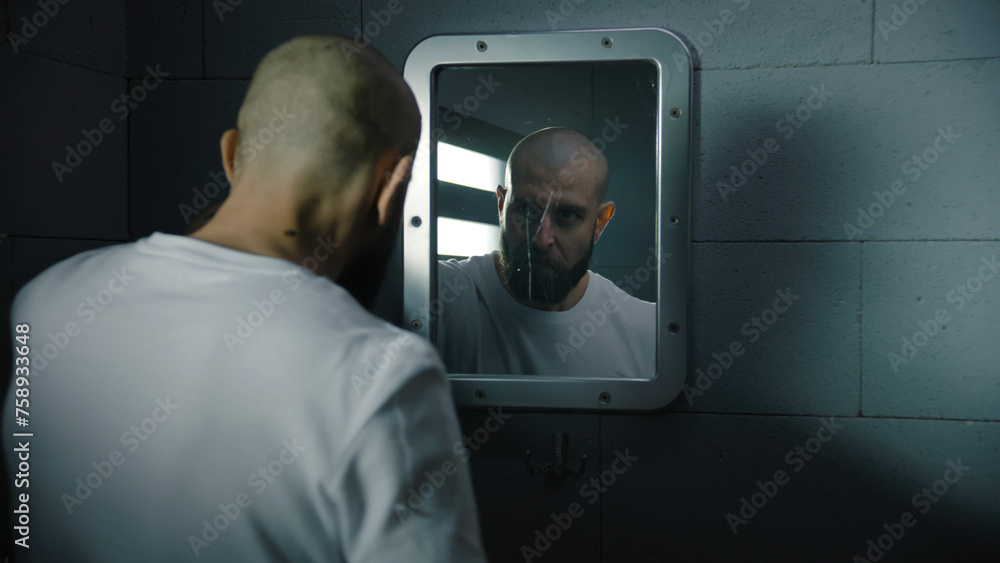 Inmate Face Male inmate wipes his face with towel and looks aggressively at himself ...