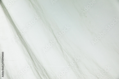 Photograph of the texture of a white tarpaulin on a construction site.