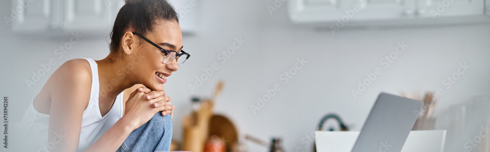 happy and young african american woman in glasses working from home remotely on her laptop, banner happy and young african american woman in glasses working from home remotely on her laptop, banner