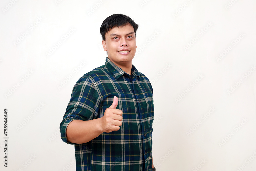 Young asian man showing thumbs up with happy face expression Young asian man showing thumbs up with happy face expression