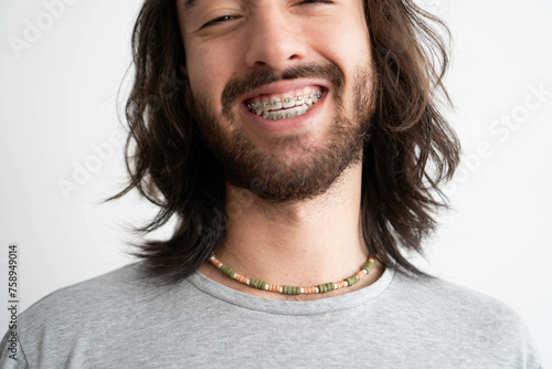 close up of a young latin man with braces wearing a colorful ceramic necklace photo