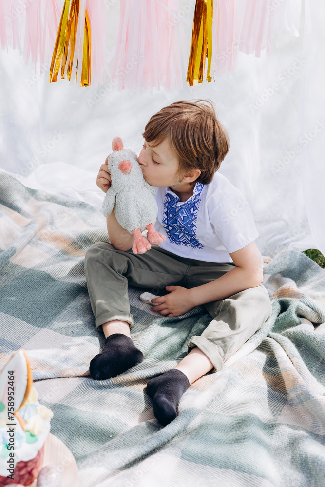 Fototapeta premium Easter celebration, Child in nature with Easter cake and eggs and Easter decor