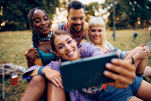 Happy woman and her friends taking selfie while attending music festival in summer.