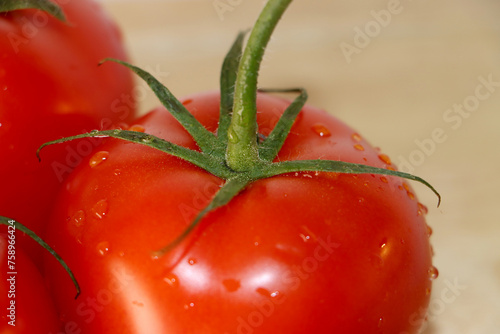 red round tomato on a wooden cutting board © Marie