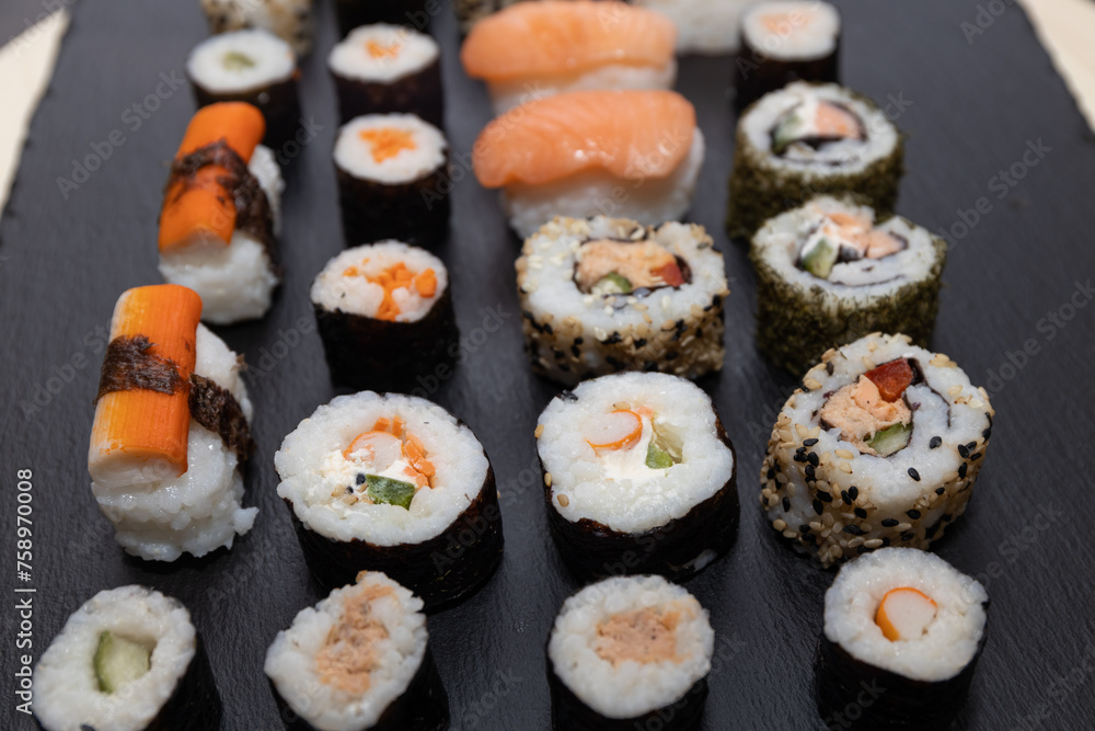 Sushi set in a plastic tray, food sticks and wasabi and ginger packets. Sushi nigiri, hosomaki, California, Sushi set in a plastic tray, food sticks and wasabi and ginger packets. Sushi nigiri, hosomaki, California,