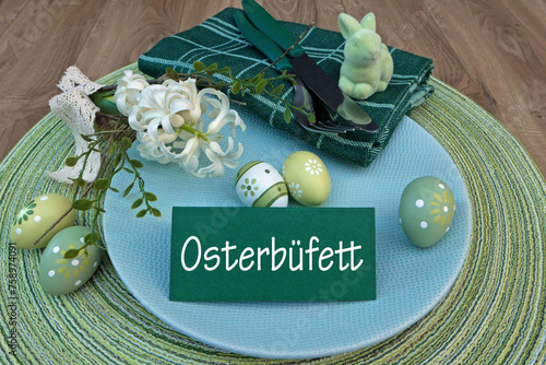 Gedeckter Ostertisch mit Osterdekoration und eine Tischkarte mit der Beschriftung Osterbüfett.