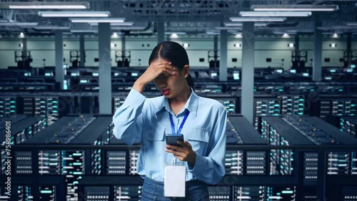 An Asian Business Woman Not Satisfied And Shakes Her Head While Using Mobile Phone In Data Center photo