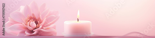 A lit candle next to a blooming pink lotus flower, set against a soft pink gradient background, creating a tranquil ambiance.