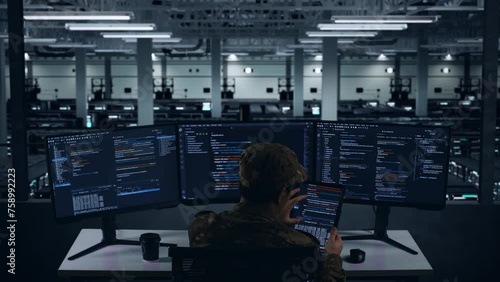 Back View Of Asian Military Working With Tablet While Write Code With Multiple Computer Screens In Data Center photo