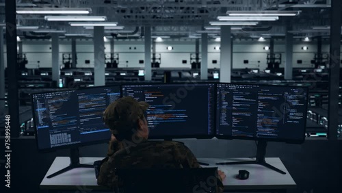 Back View Of Bored Asian Military Write Code With Multiple Computer Screens In Data Center photo