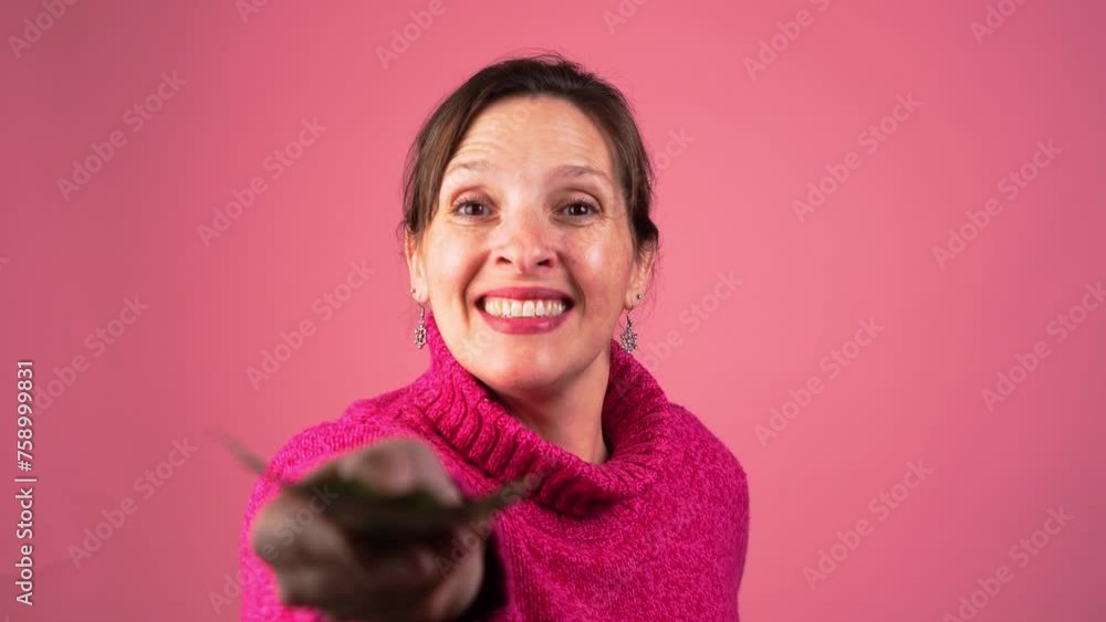 A happy woman smiles and hands money to a person who reaches for cash while making eye contact with the person. A happy woman smiles and hands money to a person who reaches for cash while making eye contact with the person.