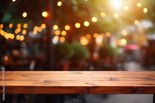 Empty wooden table top with lights bokeh on blur background. The empty wooden table top with blur background of indoor vintage cafe.