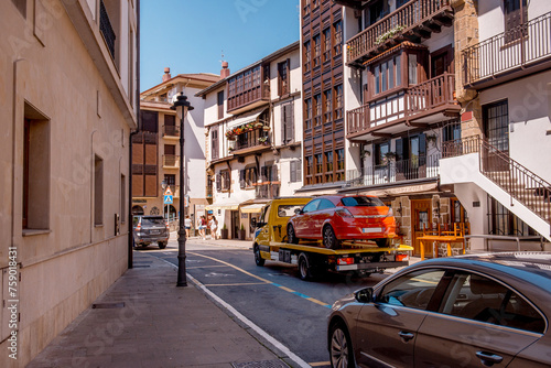 Evacuation of a car in the historical center. Prohibited parking in tourist areas. A truck trailer hauling another vehicle. Car service transportation concept. Tow truck transporting the vehicle. 