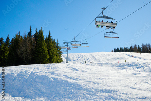 Wyciąg narciarski, kanapa, kolej linowa w ośrodku narciarskim w górach. śnieg, zima, słońce. Pod światło. © Tomasz