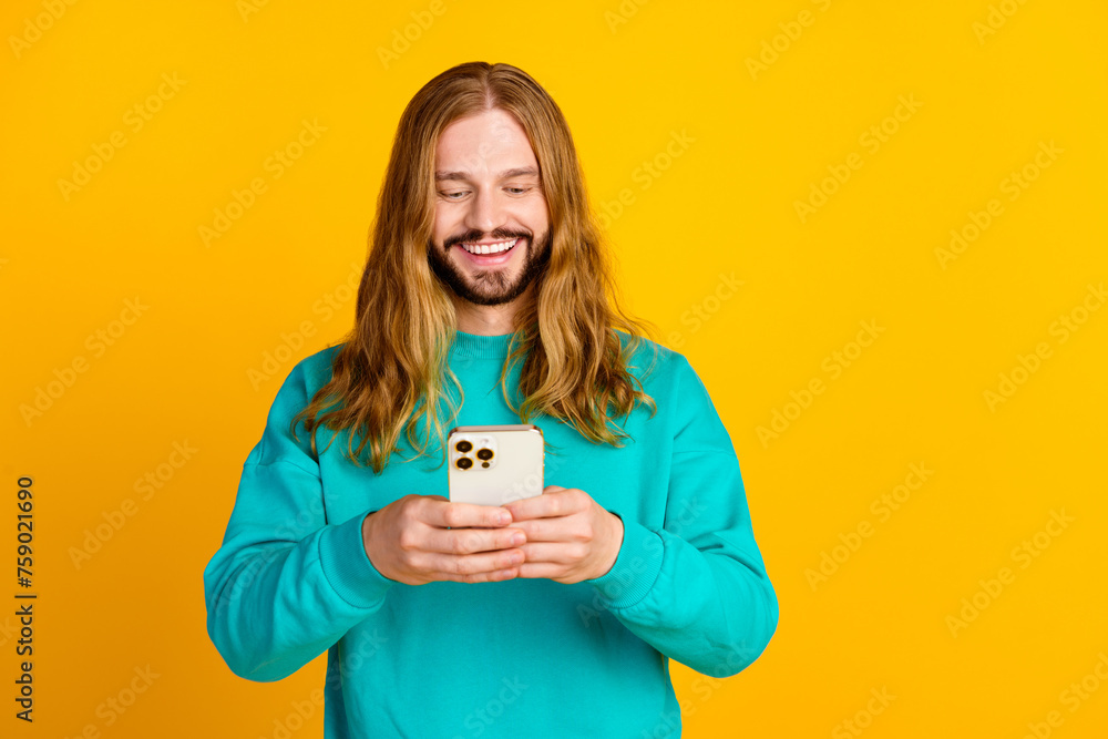 Portrait of cheerful person use apple iphone gadget chatting empty space isolated on yellow color background Portrait of cheerful person use apple iphone gadget chatting empty space isolated on yellow color background