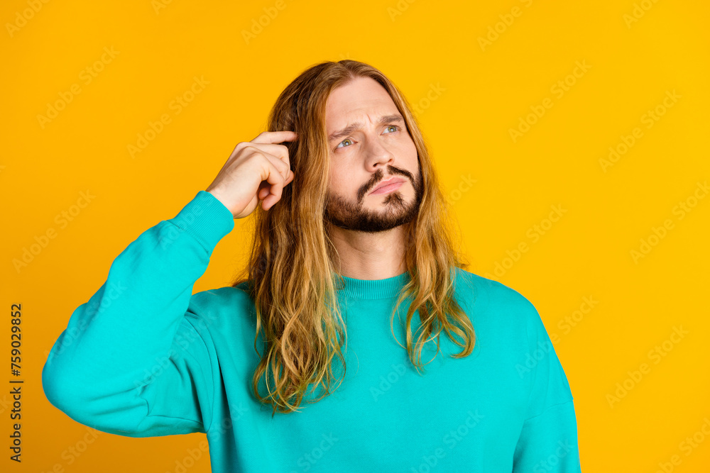 Portrait of minded pensive person hand finger scratch head look empty space isolated on yellow color background Portrait of minded pensive person hand finger scratch head look empty space isolated on yellow color background