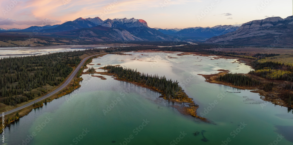 Fototapeta premium Road in Canadian Rocky Mountain Landscape. Sunrise Sky. Aerial Nature Background