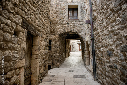 a narrow street between stone houses in Montenegro