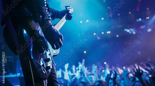 A guitarist shredding on stage, their fingers flying across the fretboard as they unleash a blistering solo, while the crowd below cheers and applauds, swept up in the excitement of the moment. photo