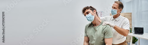 attractive mature doctor with mask helping his patient to rehabilitate in hospital ward, banner photo