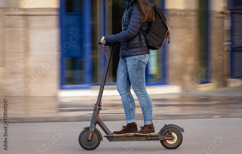 Woman pushing e-scooter in the city, Ecological transport. Sweeping motion.