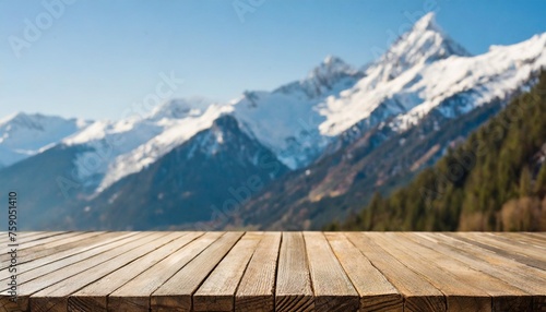 empty wooden table top with blur background of snow capped mountains © Susan