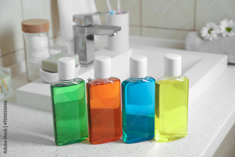 Fresh mouthwashes in bottles on countertop near sink, closeup Fresh mouthwashes in bottles on countertop near sink, closeup