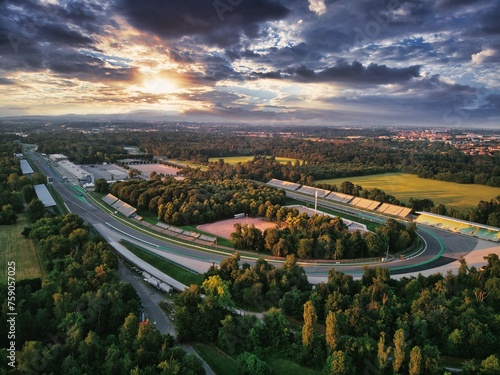 Drone shot of F1 race circuit track surrounded by greenery during sunset in Monza, Italy