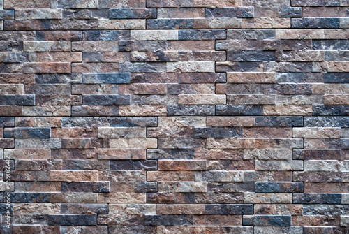Decorative tiles under the brick on the facade of the house. Abstract brown brick wall background 