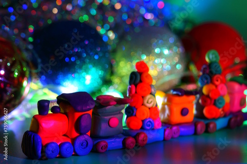 A toy train with plasticine gifts. Christmas background. New Year's holiday.