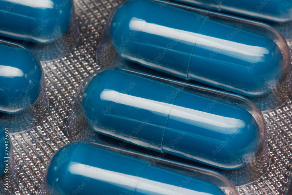 Blue capsules or pills in blister close up. - obrazy, fototapety, plakaty 