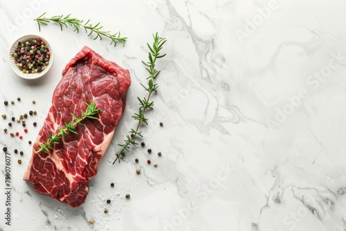 Fresh Raw Beef Steak with Herbs and Spices on White Surface