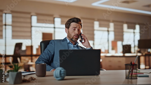 Entrepreneur man talking smartphone working at cabinet. Businessman gesturing