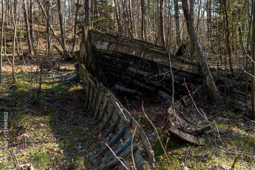 Old abandoned wooden fishing boat in the forest. Boats cemetery.