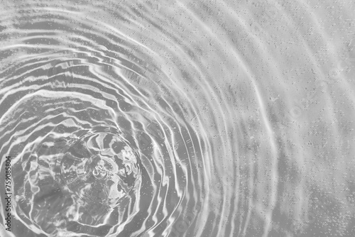 drops on water with circles on a grey background