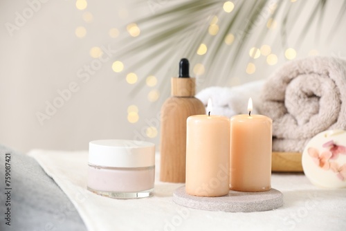 Spa composition. Burning candles and personal care products on soft surface