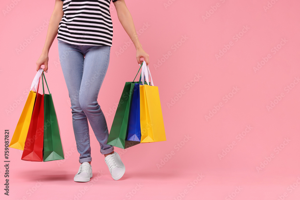 Woman with shopping bags on pink background, closeup. Space for text