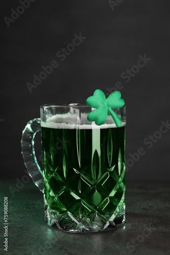 St. Patrick's day celebration. Green beer with decorative clover leaf on grey table. Space for text