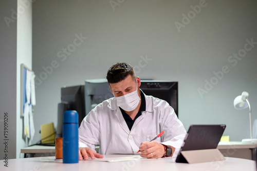 Doctor reviewing reports in break room photo