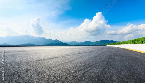 asphalt race track ground and mountain with clouds background