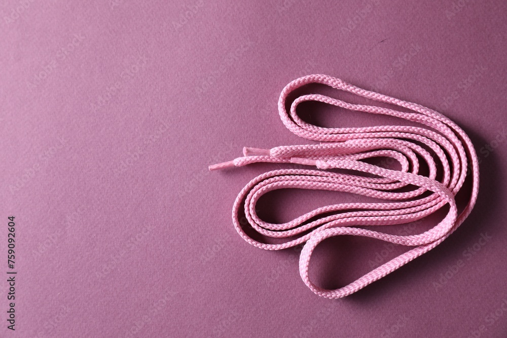 Naklejka premium Stylish pink shoe laces on violet background, top view. Space for text