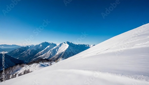 wide angle view landscape of white snowy mountains range with clear blue sky during cold winter nature concept for extreme lifestyle product background