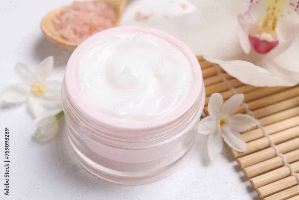 Beautiful spa composition with cosmetic products and flowers on white table Beautiful spa composition with cosmetic products and flowers on white table