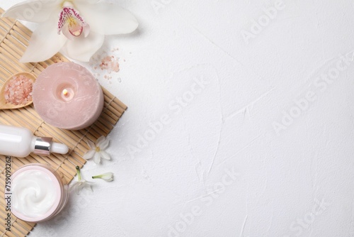 Beautiful spa composition with cosmetic products and flowers on white table, flat lay. Space for text