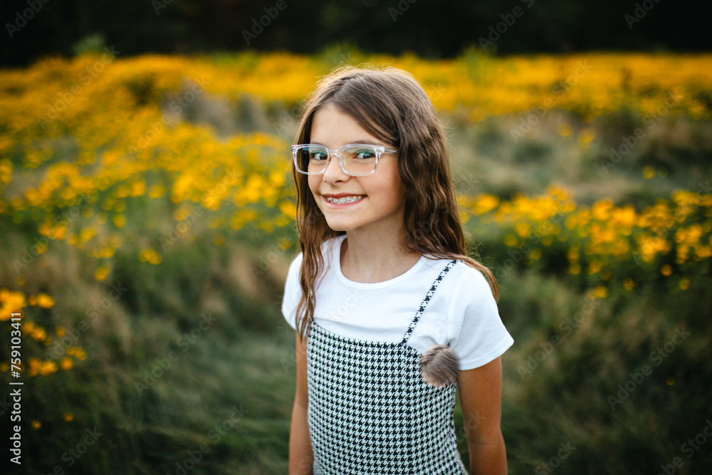 © Maria Manco/Stocksy - Preteen smiles at camera in wildflower field © Maria Manco/Stocksy - Preteen smiles at camera in wildflower field