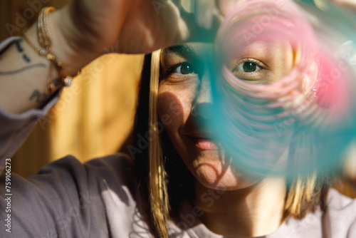 A woman with a rainbow helical spring toy photo